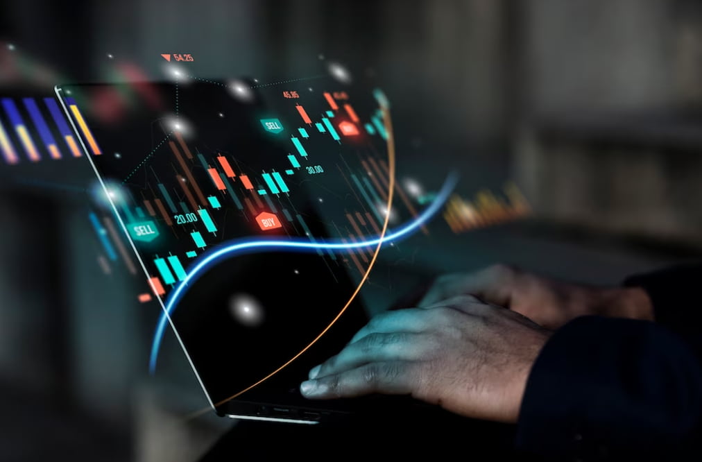 hands typing on the laptop keyboard and graph of trading on the screen