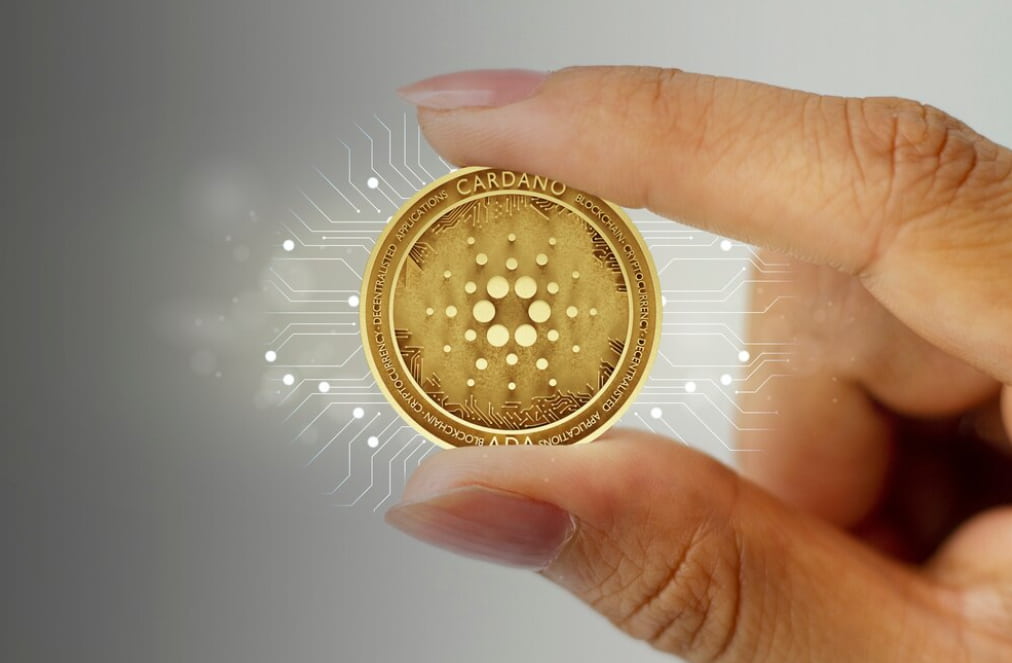 hand holding a Cardano coin  and glowing white lines around it