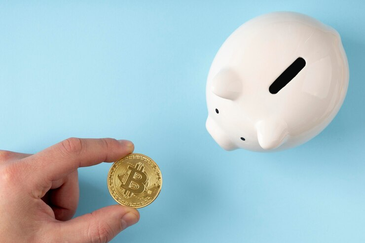 Top View Piggy Bank and Person Holding a Bitcoin